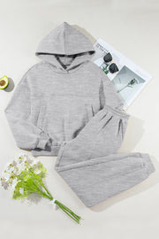 Gray relaxed fit lounge set with seam detail, featuring a hooded sweatshirt with pockets and matching sweatpants.