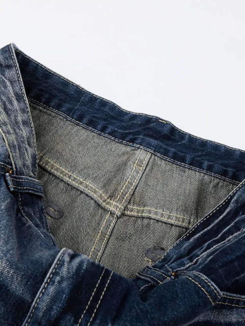 Men's distressed blue denim jeans with bootcut leg and visible stitching detail.