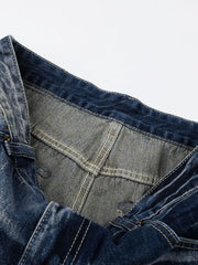 Men's distressed blue denim jeans with bootcut leg and visible stitching detail.