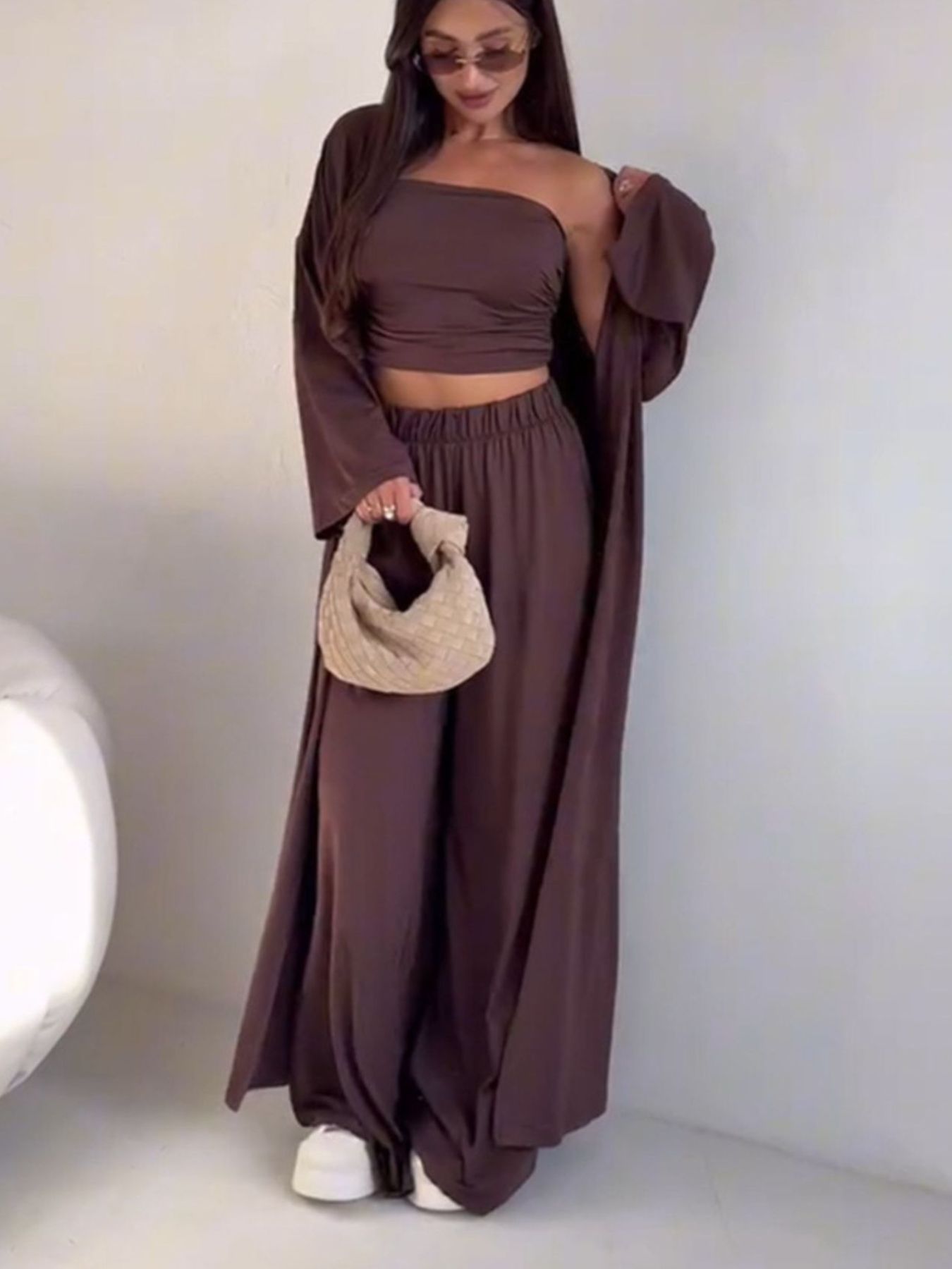 Dark brown three-piece outfit set with a long cardigan, strapless crop top, and wide-leg pants.