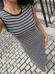Sleek black and white striped knit maxi dress with a sleeveless, bodycon fit.