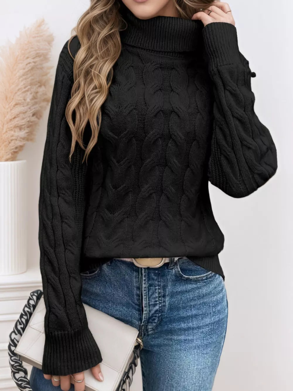 Black cable-knit turtleneck sweater with ribbed cuffs and hem.