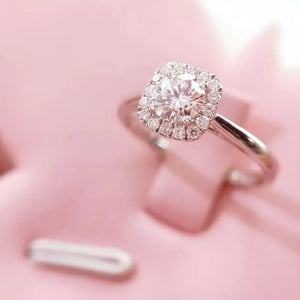 Elegant moissanite and sterling silver ring with cushion-cut center stone and halo.