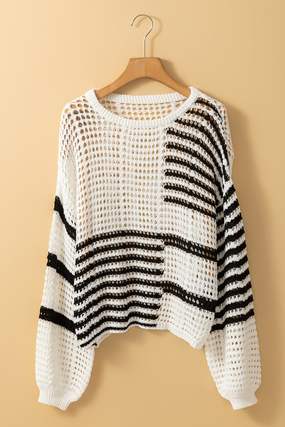 White crochet knit pullover with black graphic stripes and balloon sleeves.