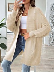 Tan ribbed knit cardigan with pearl buttons and a draped neckline.