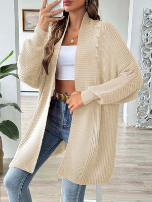 Tan ribbed knit cardigan with pearl buttons and a draped neckline.
