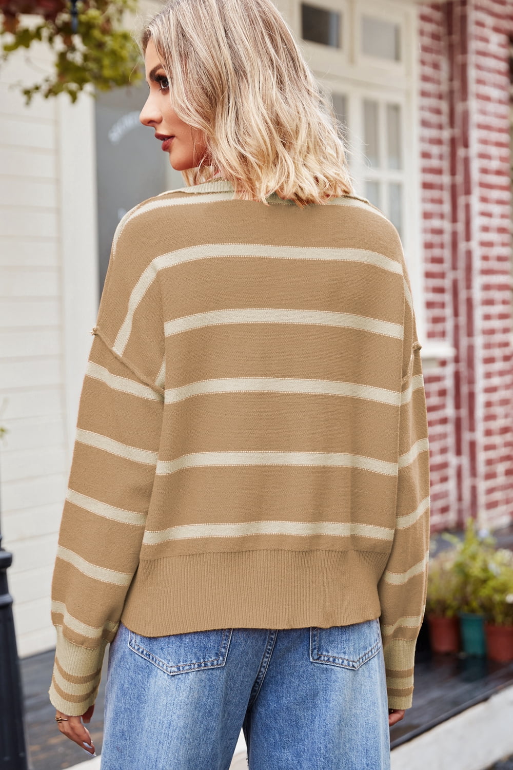 Tan striped knit sweater with polo neckline and long sleeves.