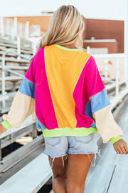 Colorblock paneled sweatshirt with neon trim in pink, yellow, blue, and cream.