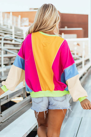Colorblock paneled sweatshirt with neon trim in pink, yellow, blue, and cream.