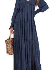 Blue smocked V-neck tiered maxi dress with long sleeves and ruffled cuffs.
