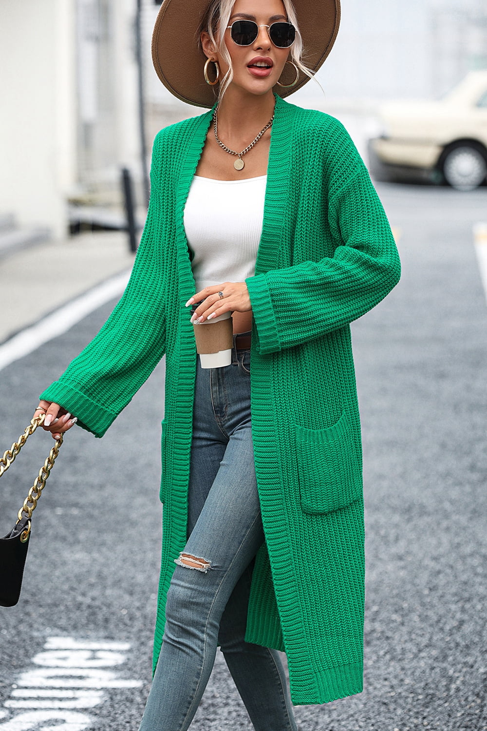 Green longline knit cardigan with pockets and ribbed texture.