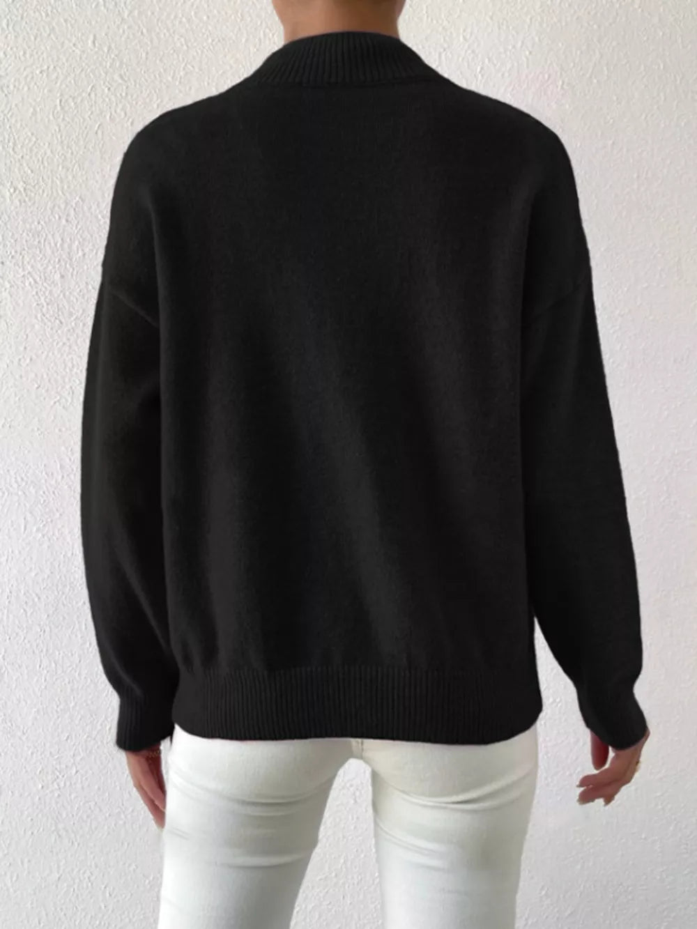 Black mock neck knit sweater with dropped shoulders, ribbed cuffs and hem.