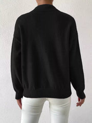 Black mock neck knit sweater with dropped shoulders, ribbed cuffs and hem.