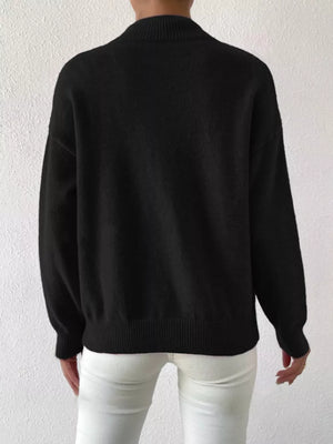 Black mock neck knit sweater with dropped shoulders, ribbed cuffs and hem.