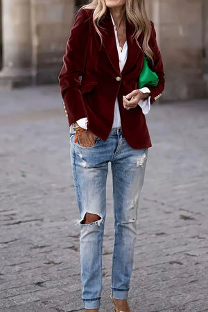 Burgundy velvet blazer with sculpted shoulders, single button closure, and gold cuff details.