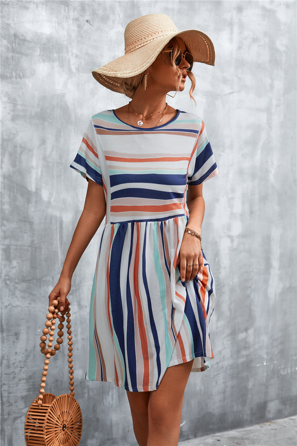 Striped yoke-seam trapeze dress in multi-color stripes with short sleeves and a round neckline.