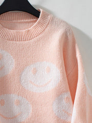 Watermelon pink knit sweater with allover white smiley face intarsia pattern and crewneck.