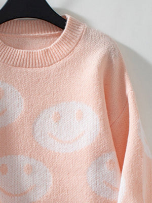 Watermelon pink knit sweater with allover white smiley face intarsia pattern and crewneck.