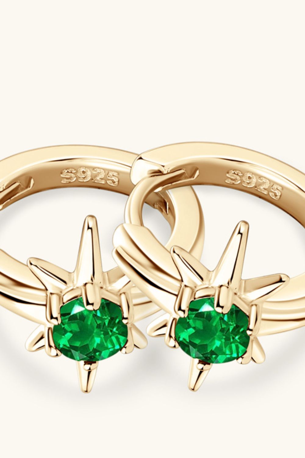 Gold starburst hoop earrings with emerald green gems and S925 marking.