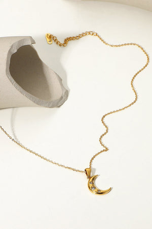 Gold crescent pendant necklace with clear stones on a delicate chain