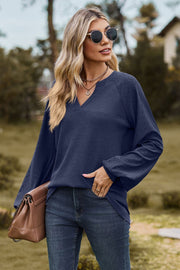 Dark blue waffle knit raglan sweater with laser cut sleeves and v-neck