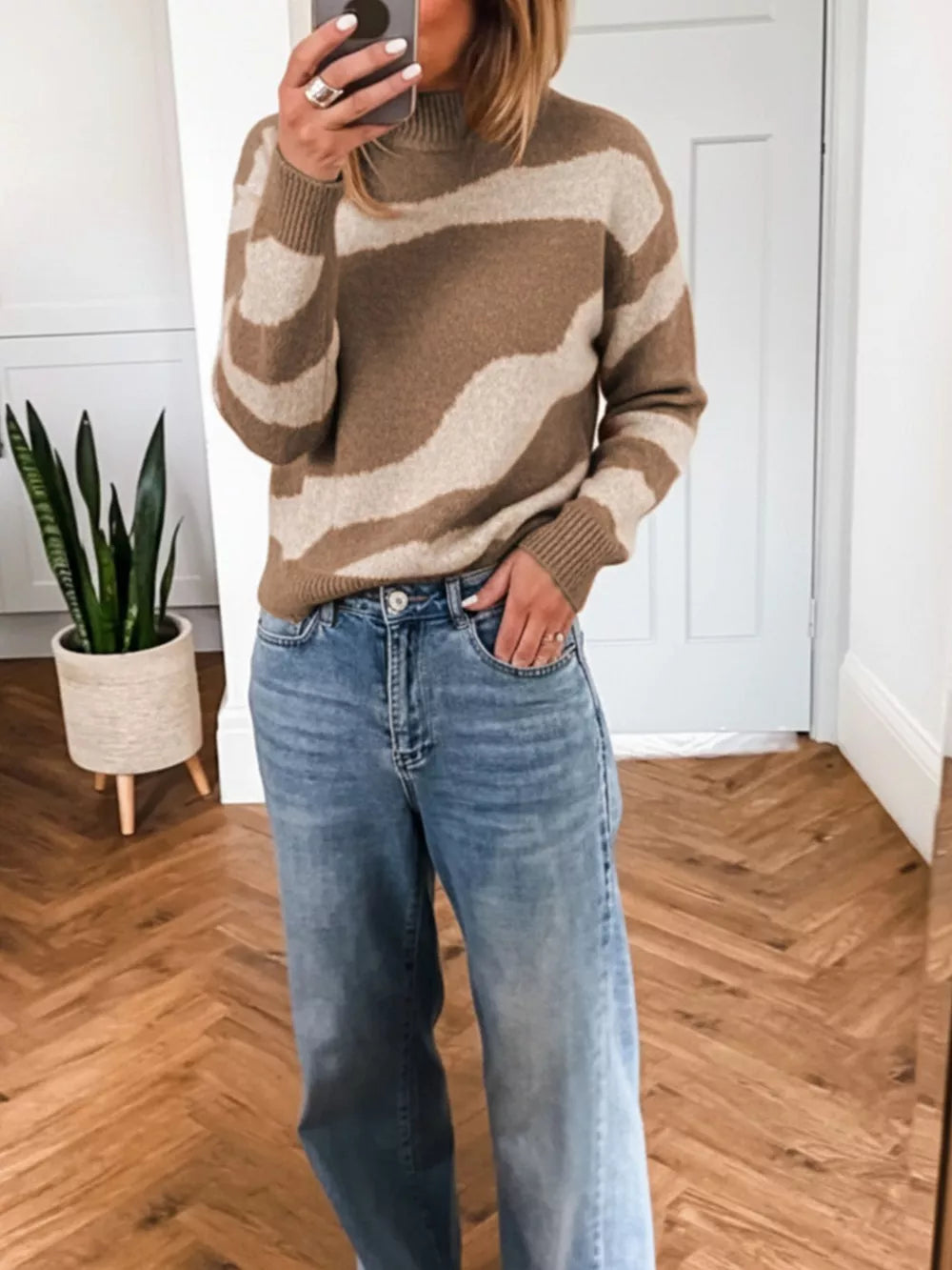 Cozy knit sweater with wavy camel and cream stripes, mock neck, and ribbed cuffs.