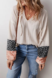 Textured sleeve henley blouse in cream with patchwork floral print sleeves and tie neckline.
