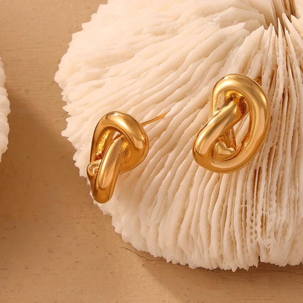 Gold sculptural knot stud earrings with a polished finish.