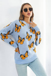 Pastel blue acrylic knit crewneck pullover sweater with all-over orange butterfly motif.