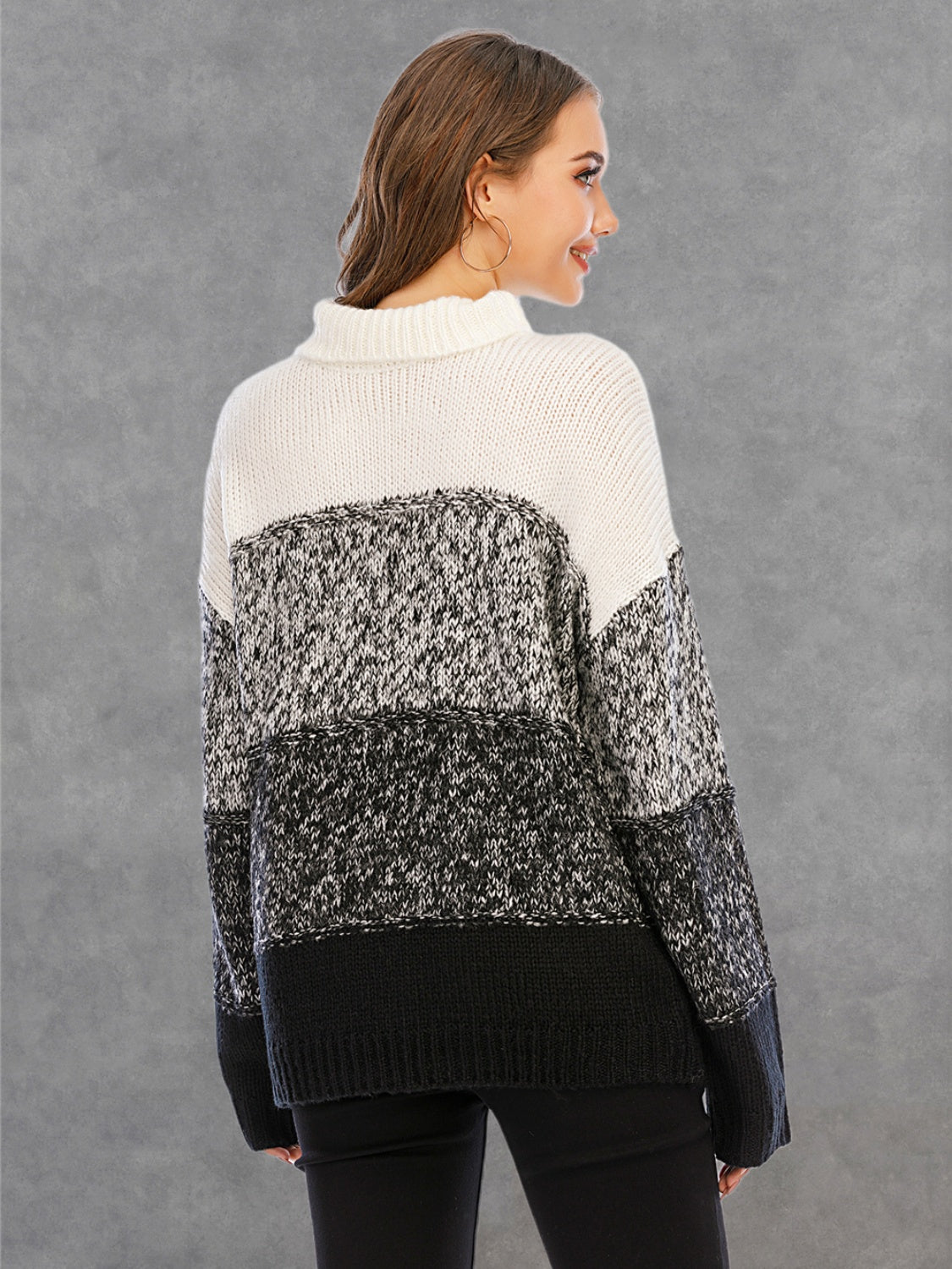 Colorblock turtleneck sweater with defined panels in white, black, and grey acrylic knit.