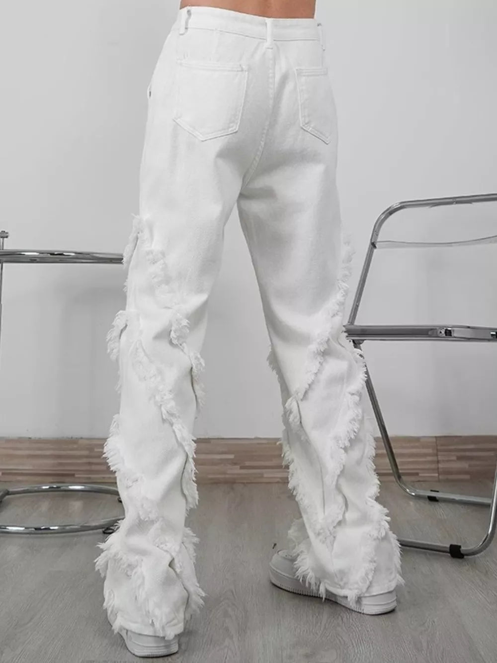 White wide-leg jeans for men with distressed fringe detailing on the legs.
