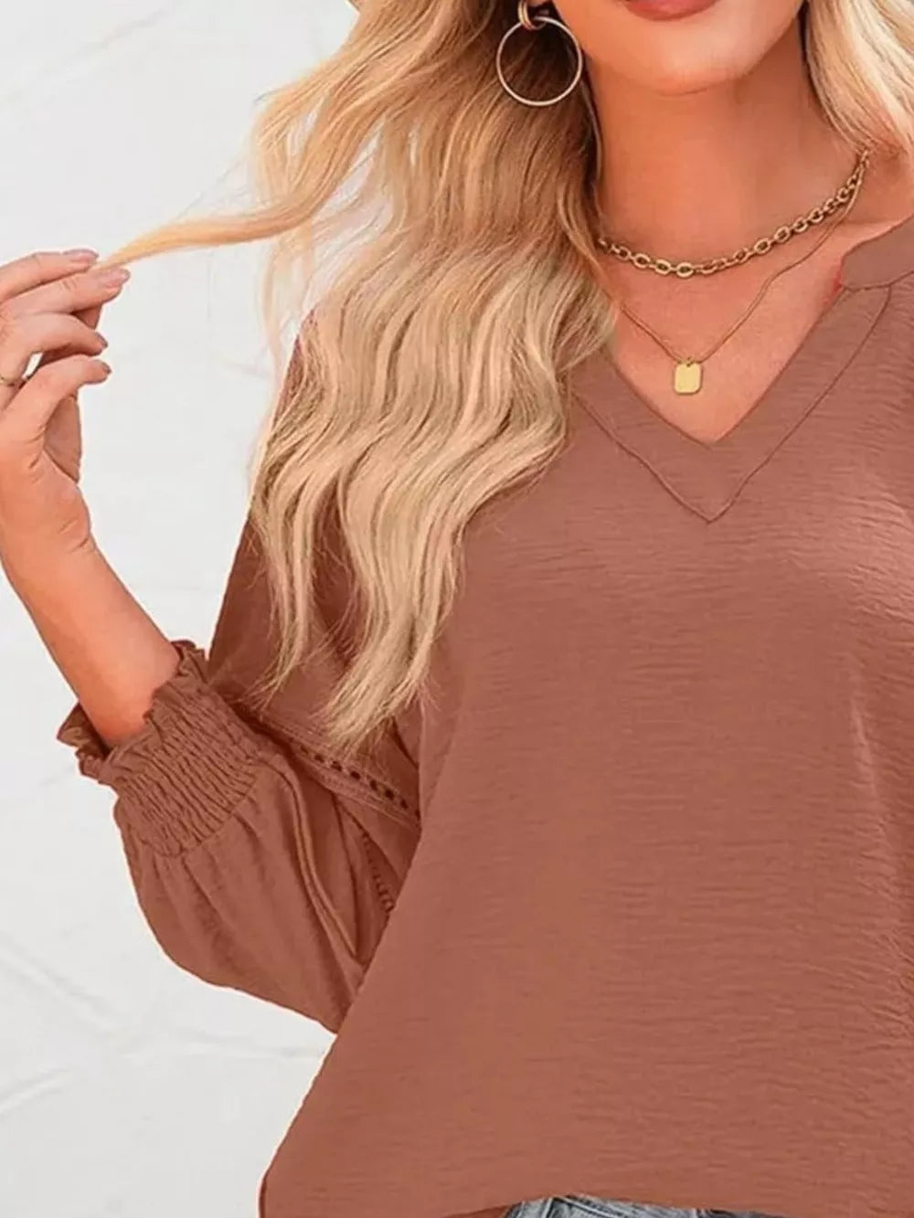 Caramel polyester blouse with V-neck, smocked cuffs, and eyelet detail on sleeves.