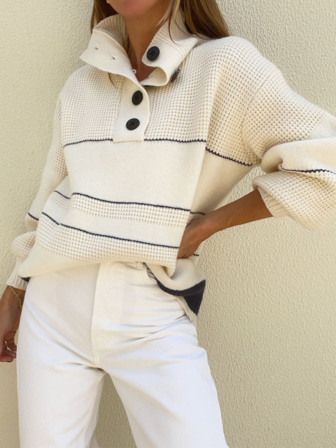 Cream waffle knit button-up collar sweater with navy stripes and black buttons.