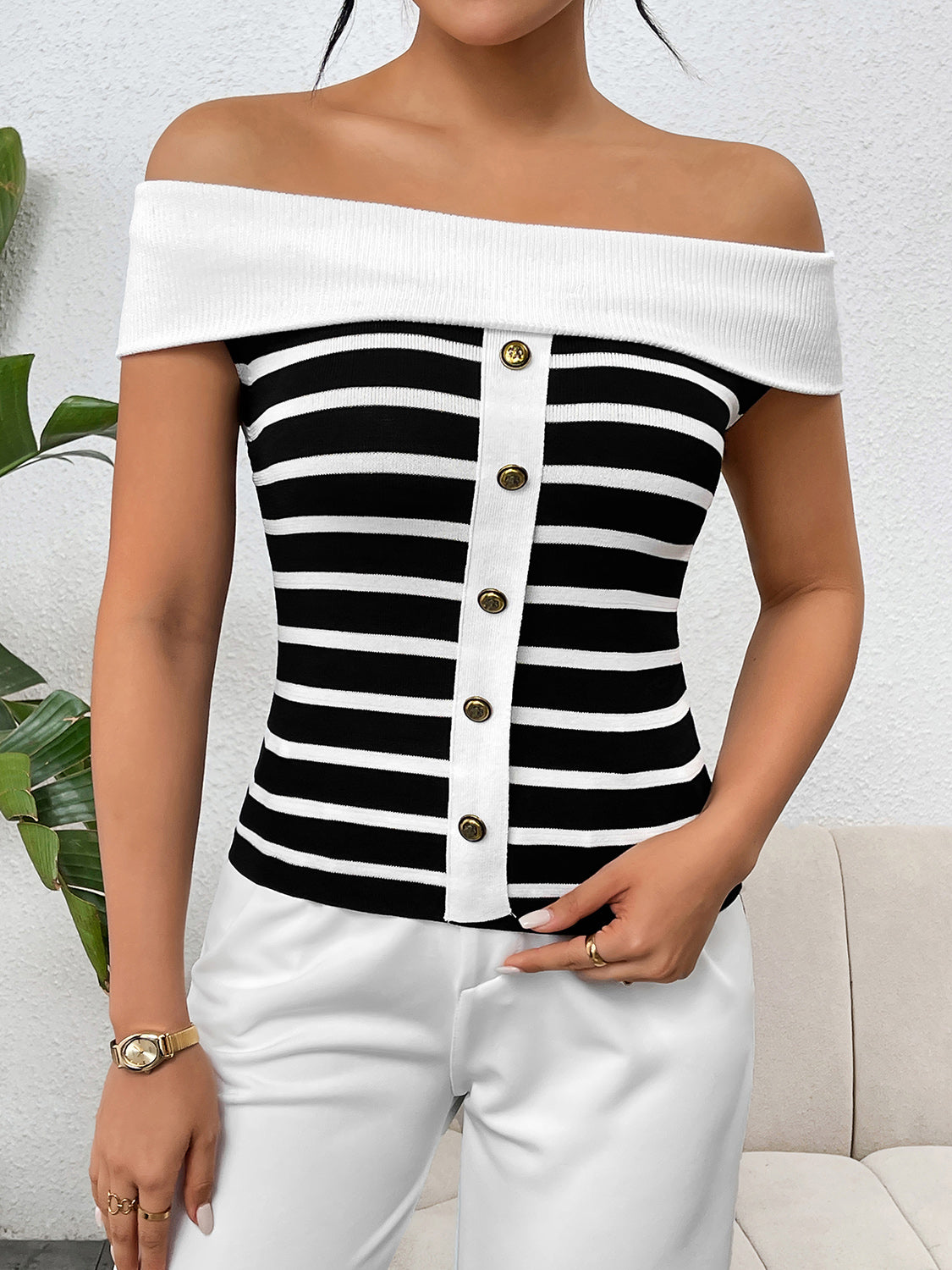 Off-shoulder black and white striped knit top with button-down front detail.
