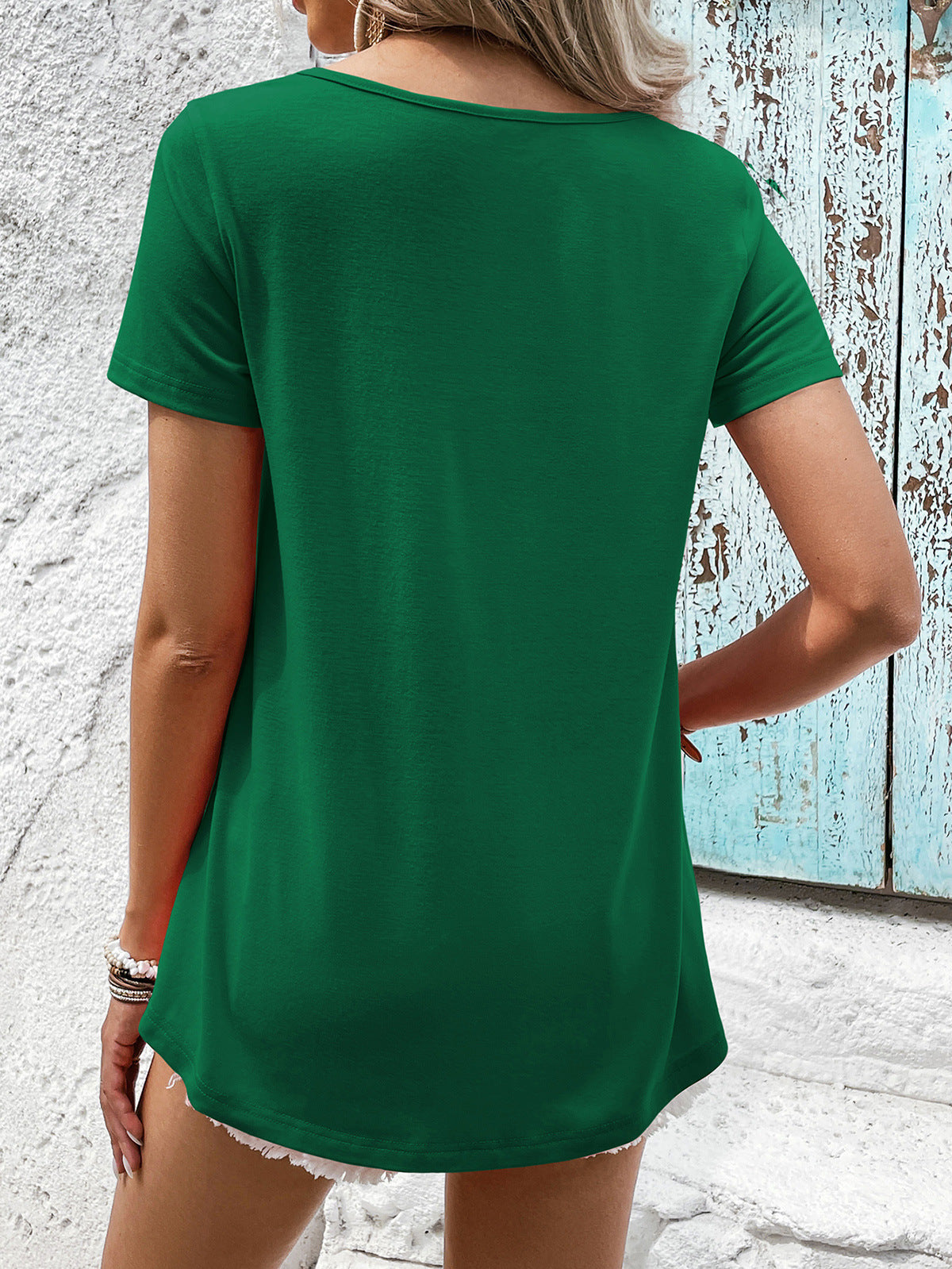 Green t-shirt with short sleeves and a floral lace yoke detail.