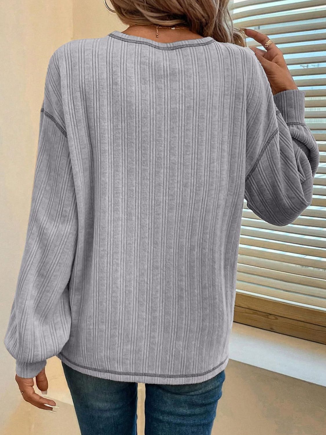 Gray ribbed knit sweater with contrast stitching and balloon sleeves.