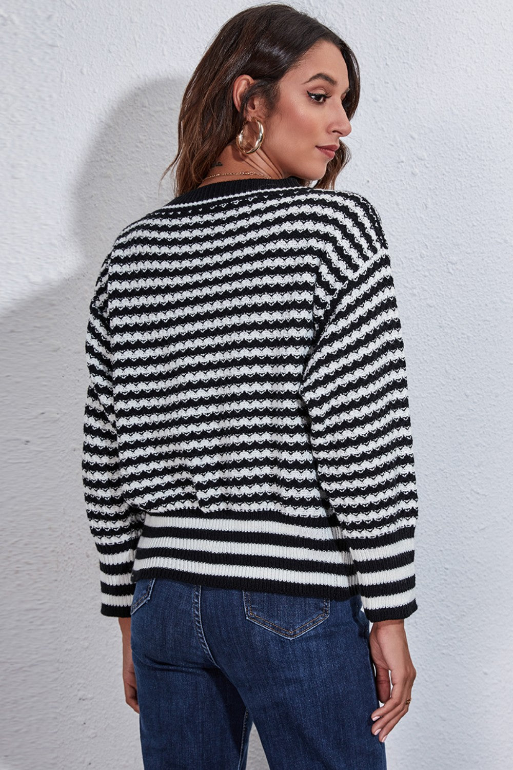 Black and white chevron stripe knit cardigan with a textured pattern and ribbed hem.