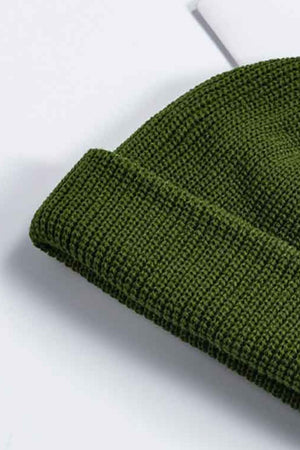 Olive green ribbed knit beanie with a turn-up cuff.