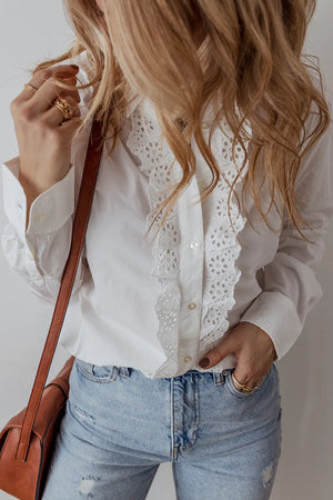 White cotton shirt with eyelet ruffle front detail and button closure.