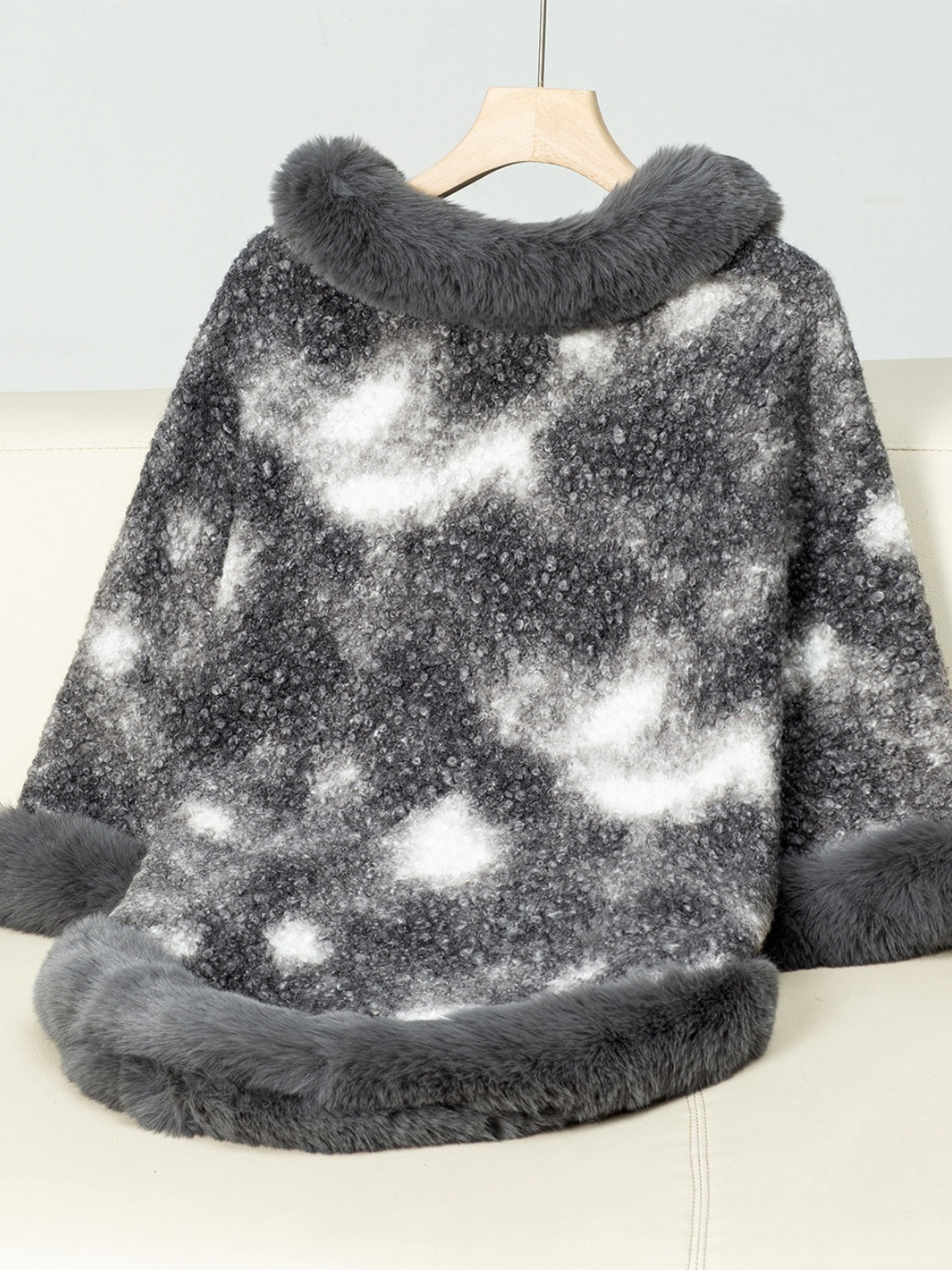 Faux fur trimmed camo poncho in Dark Gray with a textured knit and white cloud pattern.
