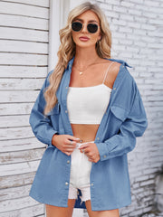 Oversized dusty blue denim shirt with front pockets and button closure.