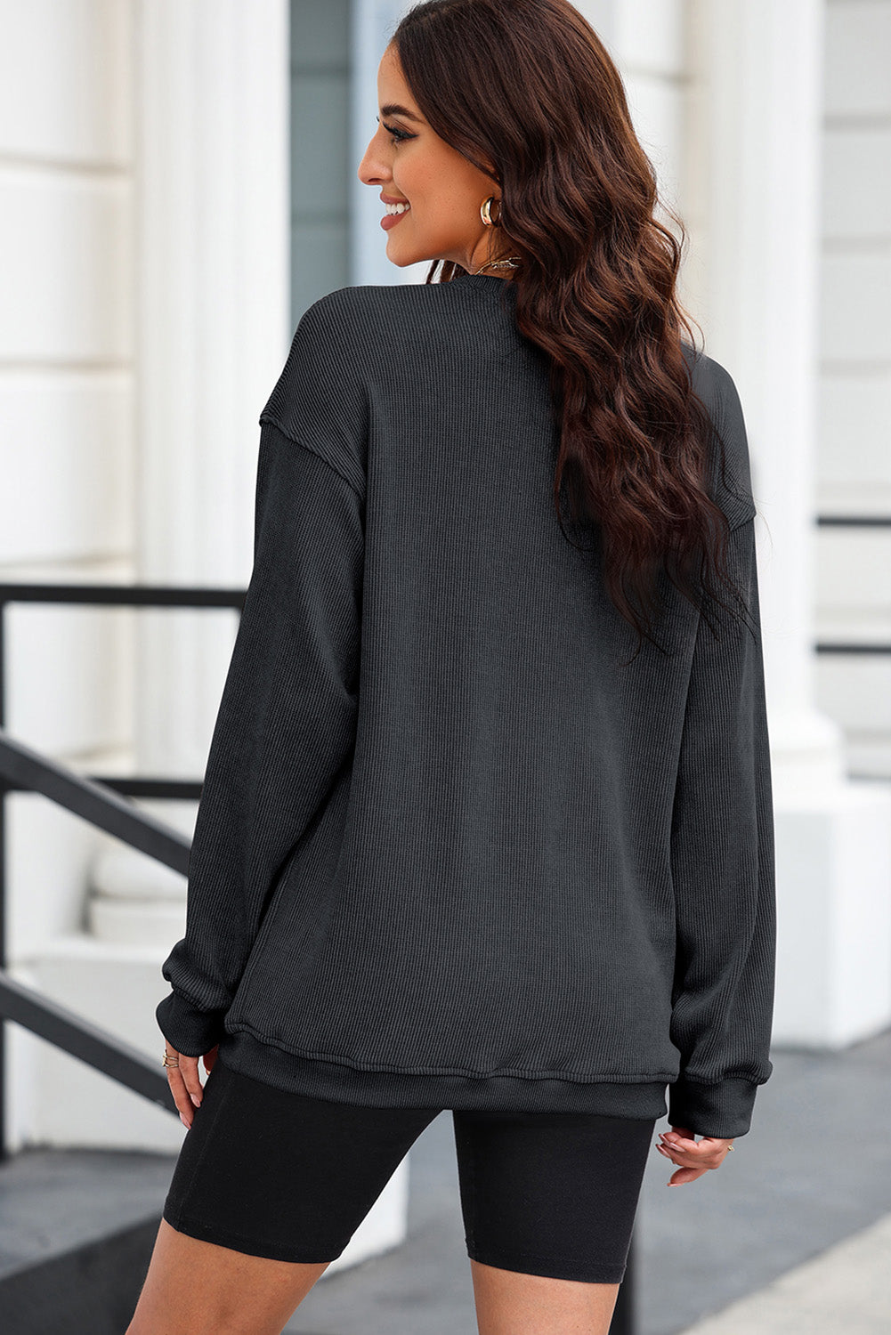Black ribbed sweatshirt with crew neck and long sleeves, made of polyester.
