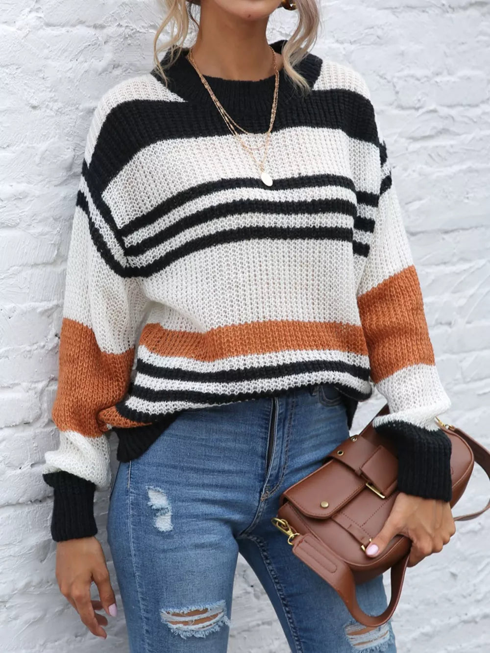 Casual striped knit sweater with color block accents in black, white, and rust orange acrylic.