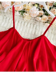Red ruffled cami with delicate spaghetti straps and a flowy silhouette.