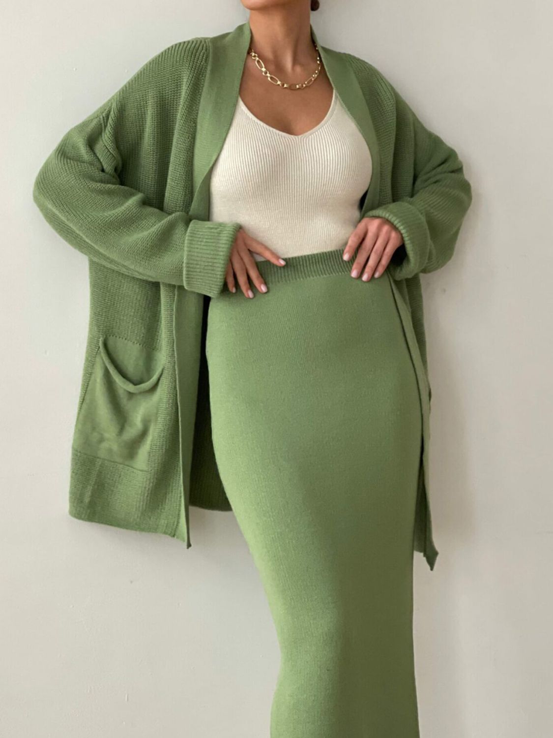 Ribbed knit co-ord set in Gum Leaf green, featuring a long sleeve cardigan with pockets and a midi skirt.