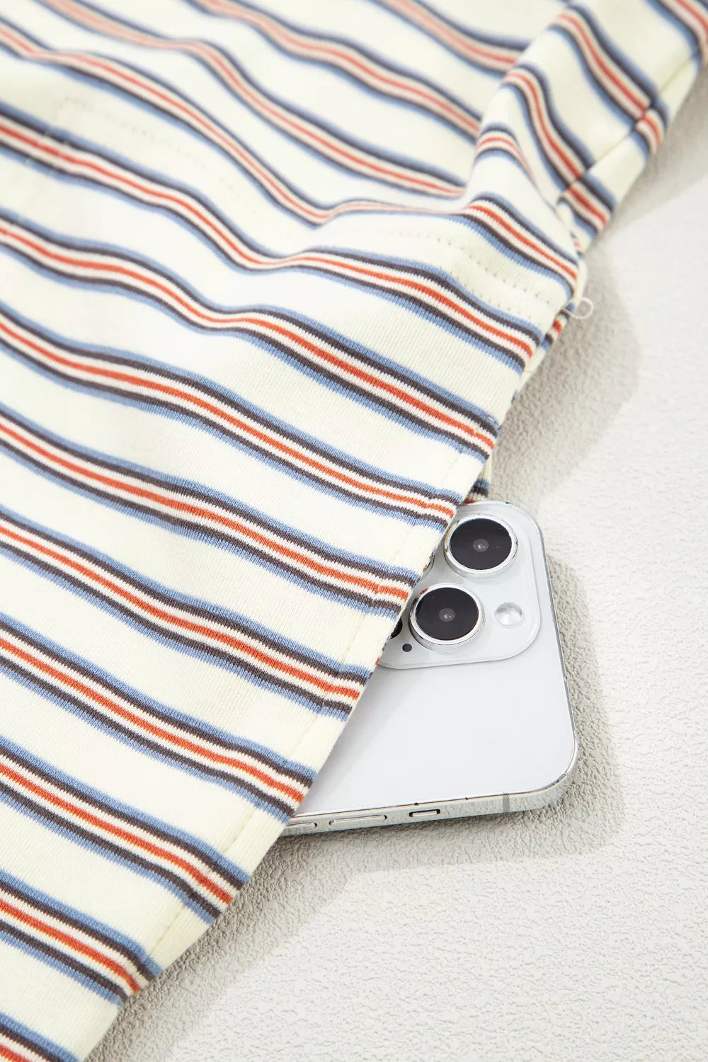 Casual striped mini dress in cotton with side pockets, showing a phone tucked in.
