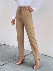 Tan textured tapered trousers with drawstring waist and pockets.