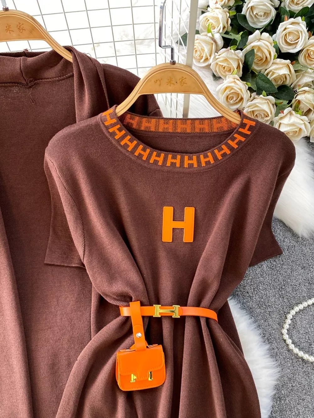 Brown knitted maxi dress and cardigan ensemble with orange trim, H logo, and belt with mini bag.