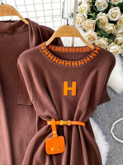 Brown knitted maxi dress and cardigan ensemble with orange trim, H logo, and belt with mini bag.