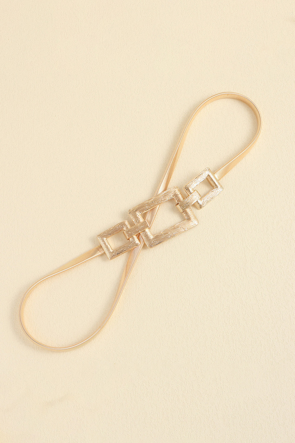 Gold elastic belt with textured geometric rectangle buckle detail